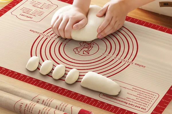 Rolling dough on silicone mat with measurement grid